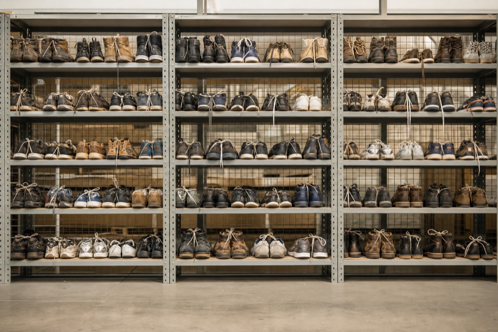Pairs of used shoes sorted and tied together on warehouse shelves